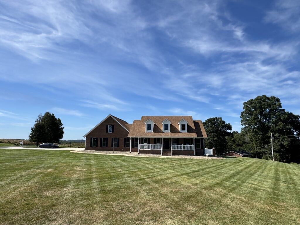 Same Morrow Ridge owner's lawn during a prior drought cycle, showing brown striping and dry patches across professionally maintained tall fescue in the NC Piedmont