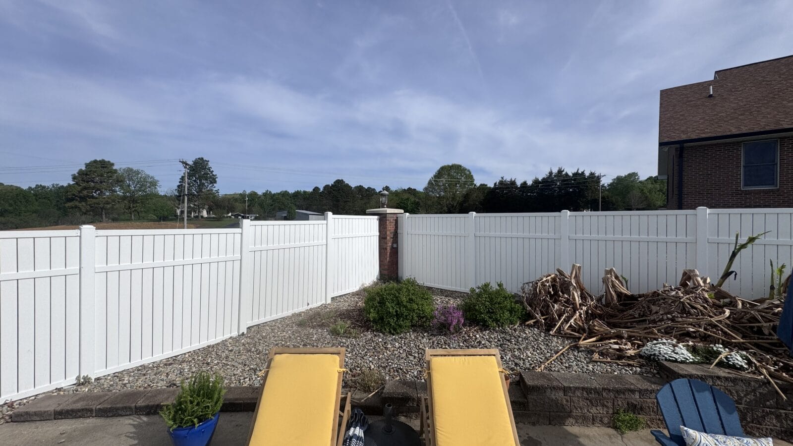 Overgrown planter bed with compacted soil and undefined edges in a Charlotte NC front yard before renovation